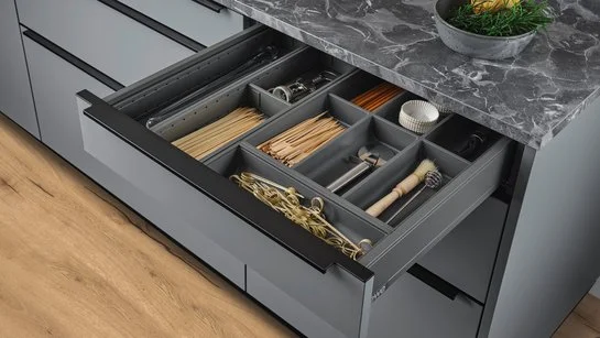 ewe Legrabox AmbiaLine Ladeneinsatz-Set aus Stahlblech oriongrau 60 cm Messereinsatz und Utensilieneinsatz in einer geöffneten Schublade in einer Kücheninsel