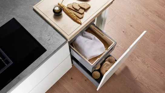 ewe Legrabox Unterschrank zur Brotaufbewahrung 60 cm Kücheinsel mit geöffneter Lade, darin ein brotsack